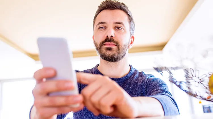 Man with a beard interacting with a digital device