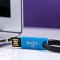 Hey custom and printer thumb drive with the logo sitting next to a laptop