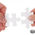 hands holding blank custom puzzle pieces